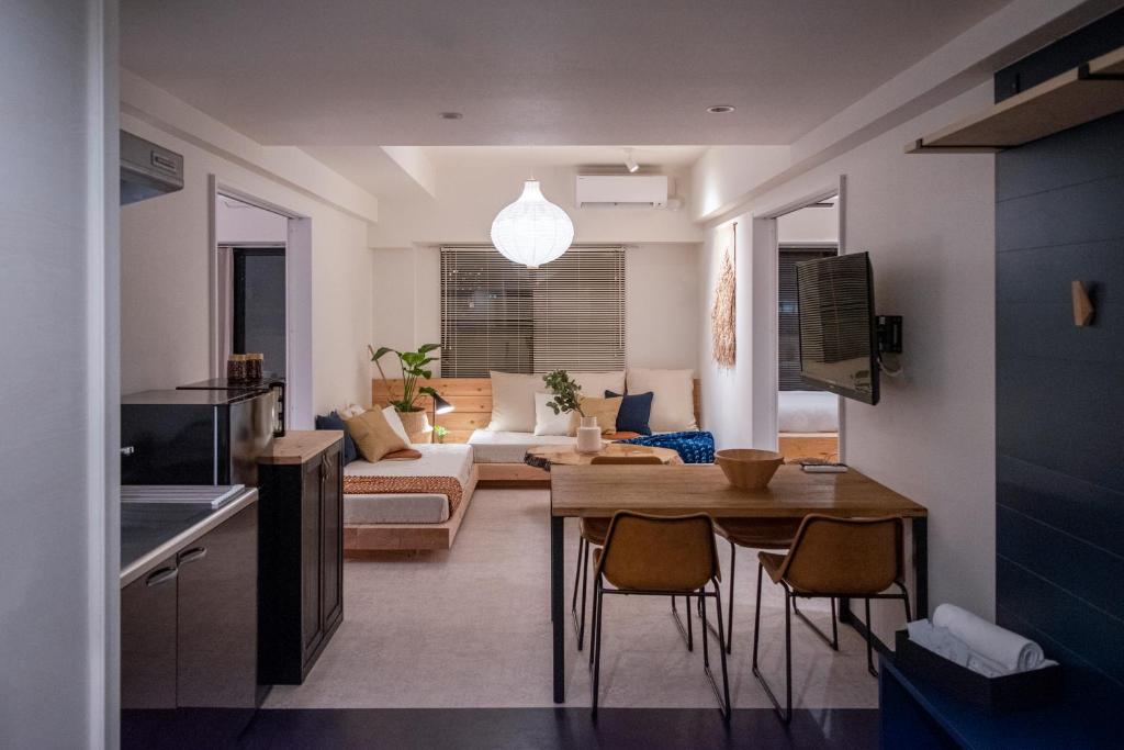 a living room with a couch and a table and chairs at EARTHMANS OSAKA-JO in Osaka