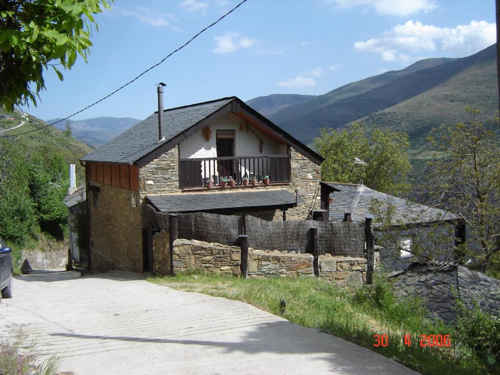 an old stone house with a balcony in the mountains at Carriles Romanos in Odollo