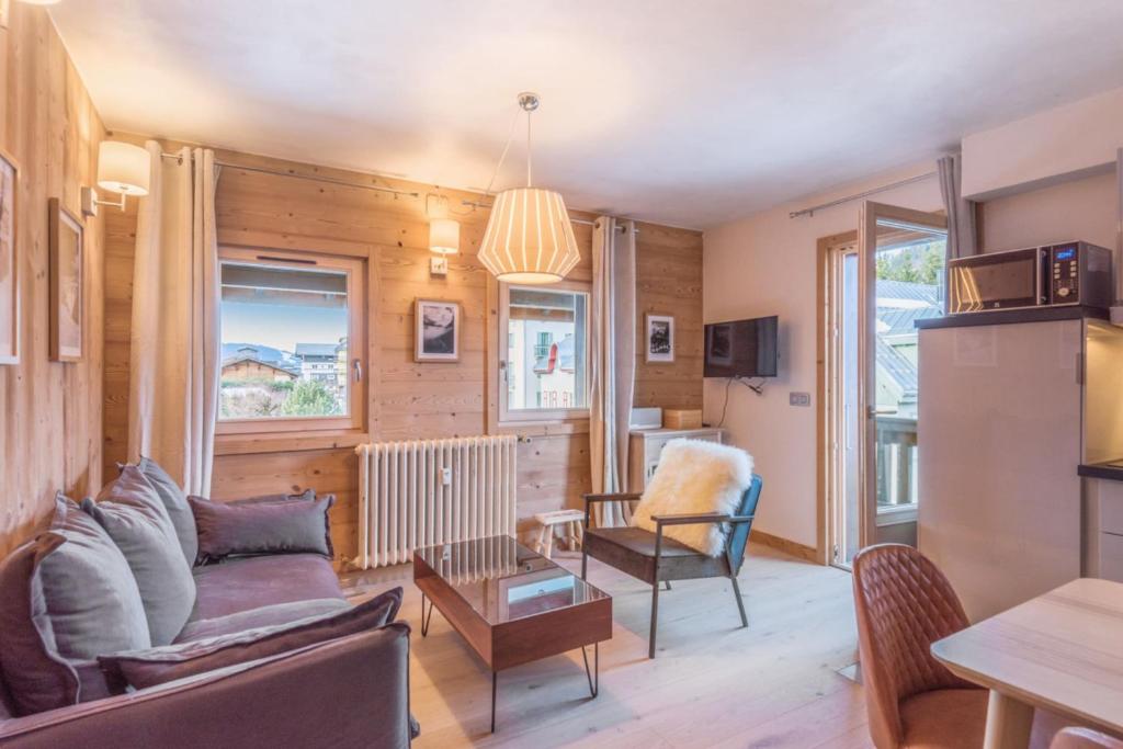 a living room with a couch and a table at Appartement Hibou - Welkeys in Megève