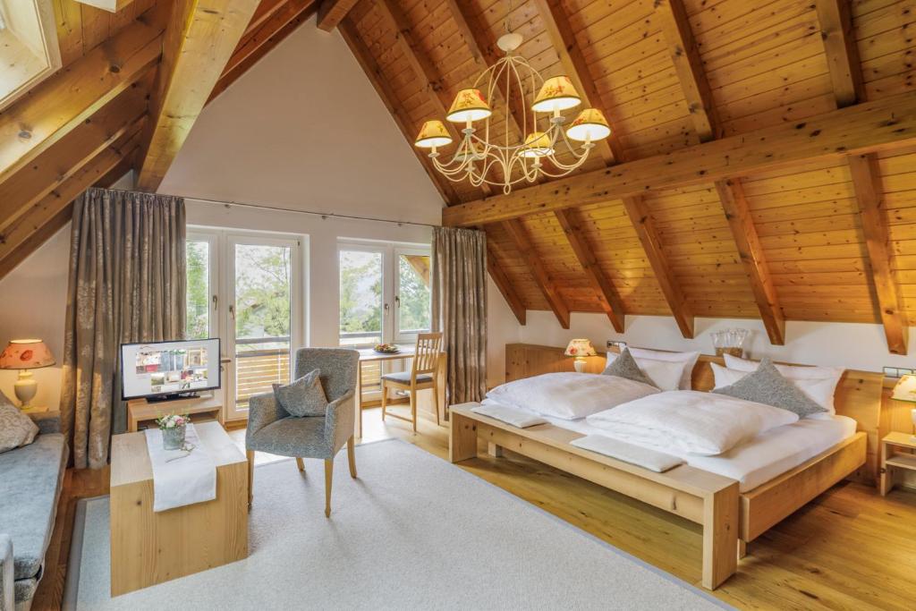 Un dormitorio con una cama grande en una habitación con techos de madera. en Schlegelhof, en Kirchzarten