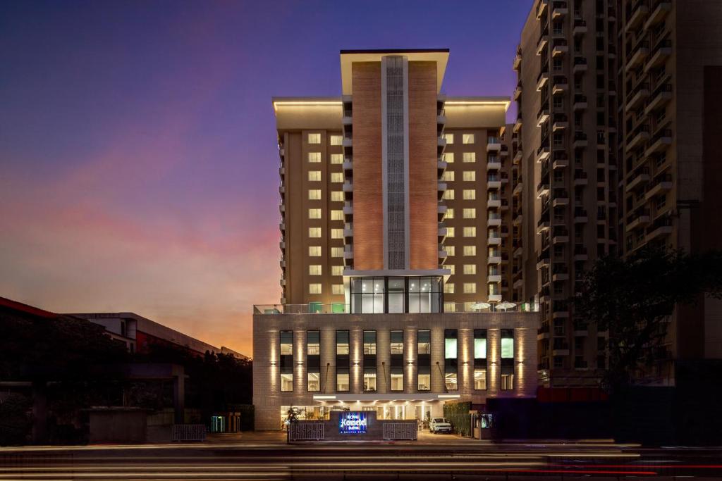 a tall building with a lit up sign in front of it at Royal Hometel Suites in Mumbai