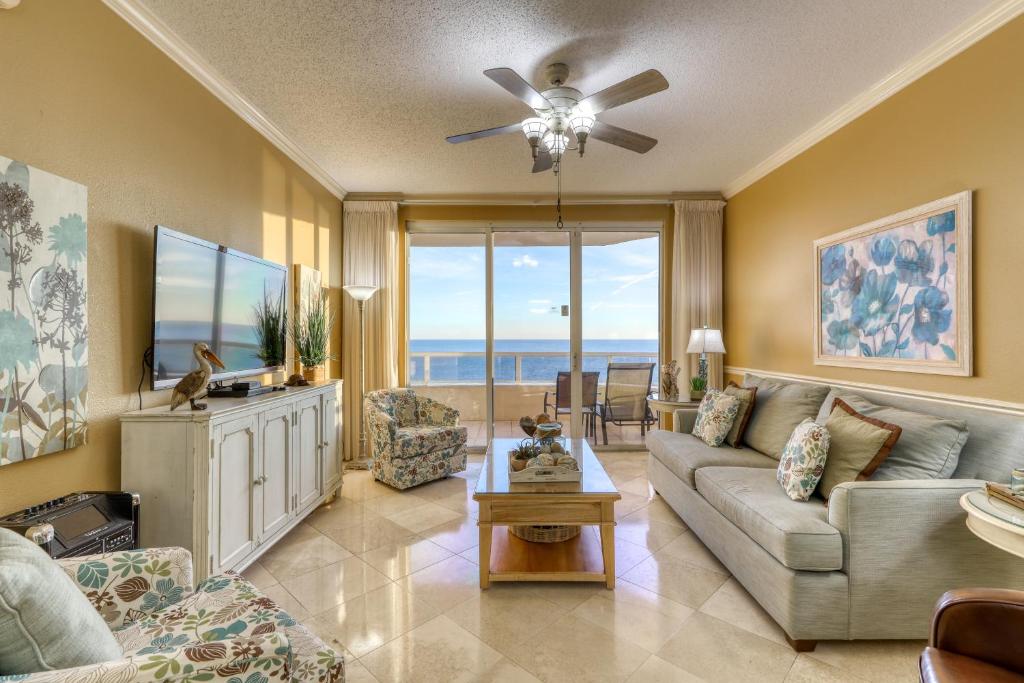 uma sala de estar com um sofá e uma ventoinha de tecto em Enclave 1004 em Orange Beach