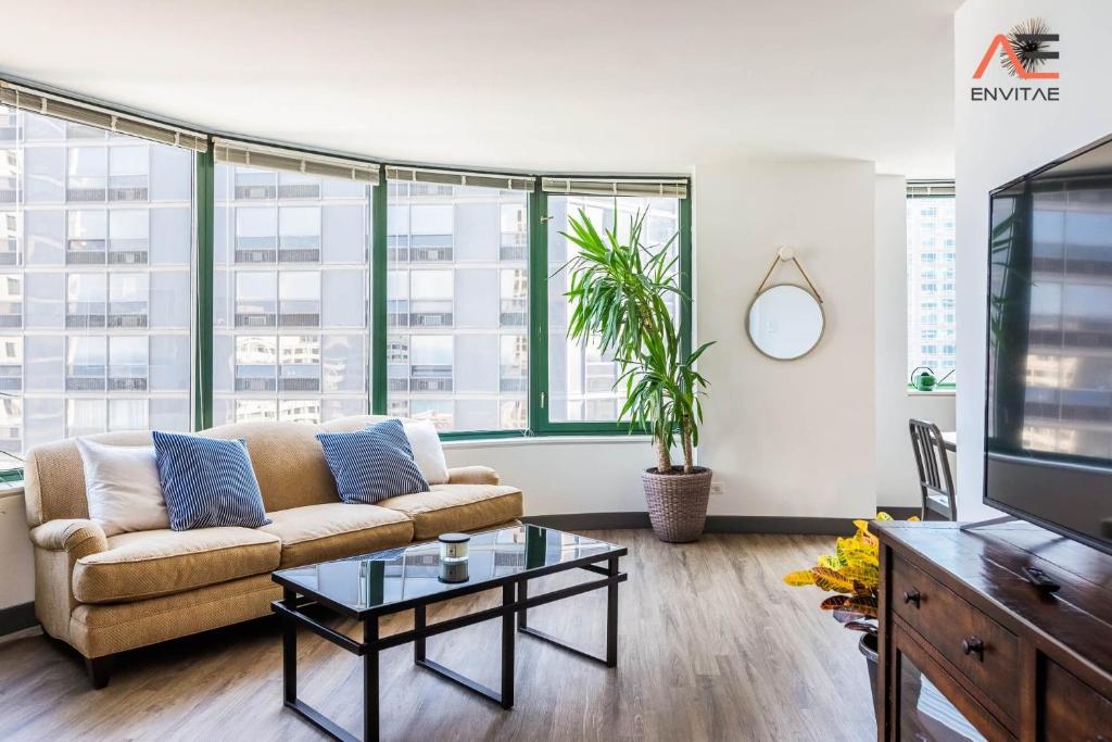 a living room with a couch and a tv at ENVITAE 3BR Luxury Corner Loft with Navy Pier Views in Chicago