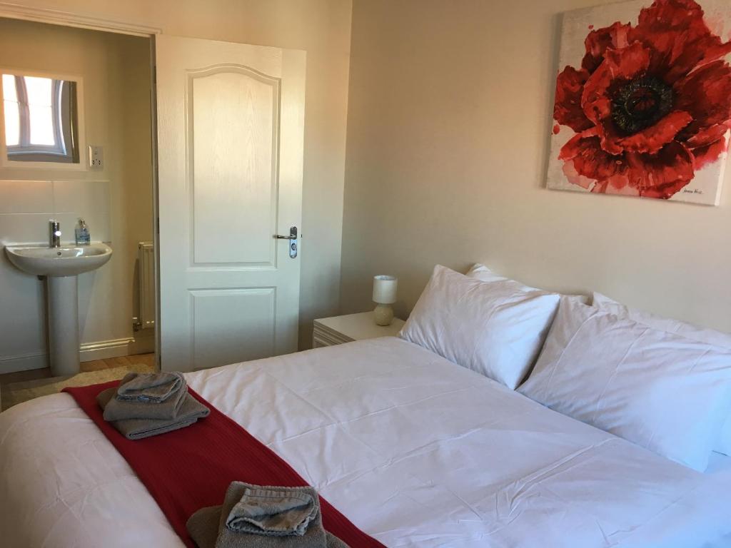 a bedroom with a white bed and a sink at New and Comfortable with Parking in Andover