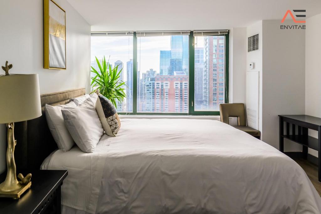 um quarto com uma cama grande e uma janela grande em ENVITAE 3BR Spacious Lux Skyview Of Navy Pier em Chicago