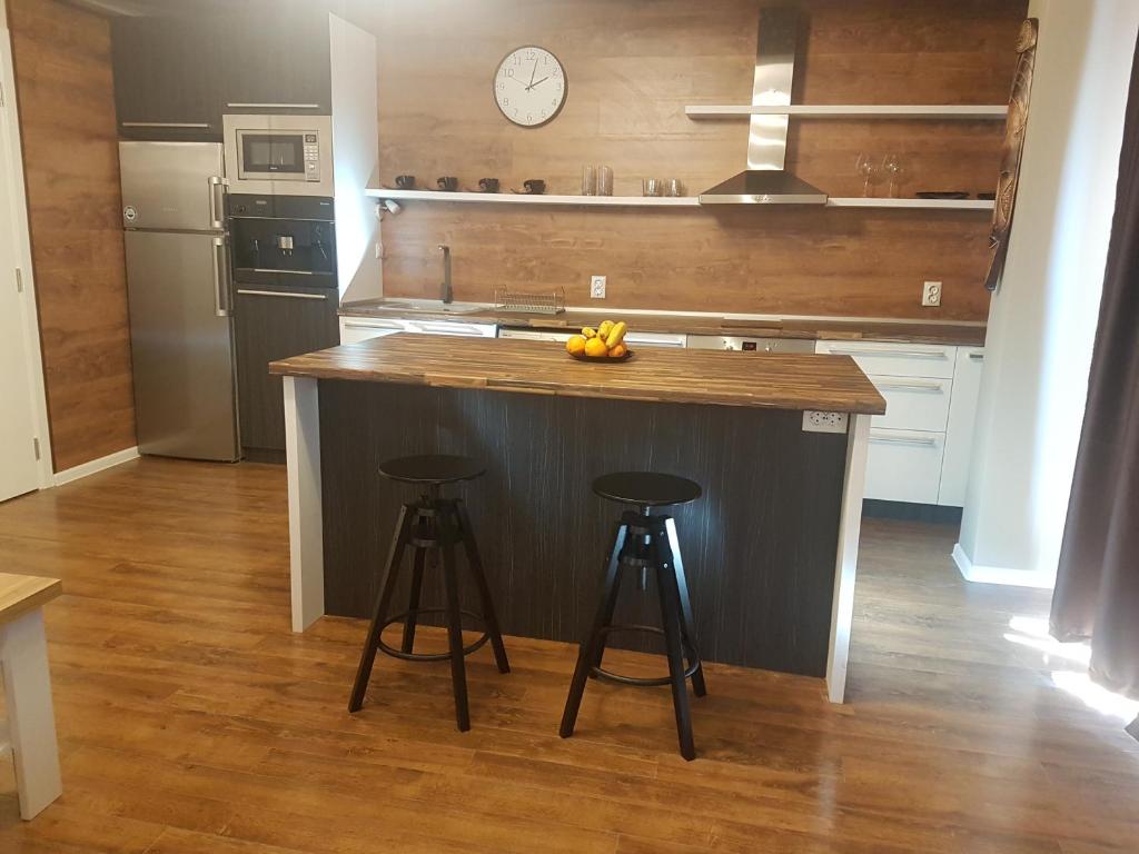 a kitchen with a island with stools and a clock at LUXURY SUITE 2 in Karlovo