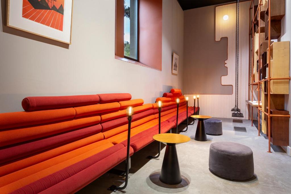 a room with a couch and some tables and stools at One Shot Tabakalera House in Donostia-San Sebastián
