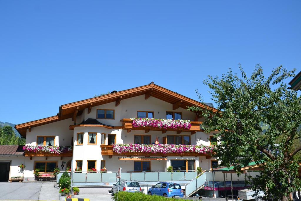 un grand bâtiment avec des fleurs sur les balcons dans l'établissement Appartement Ahornblick, à Schwendau