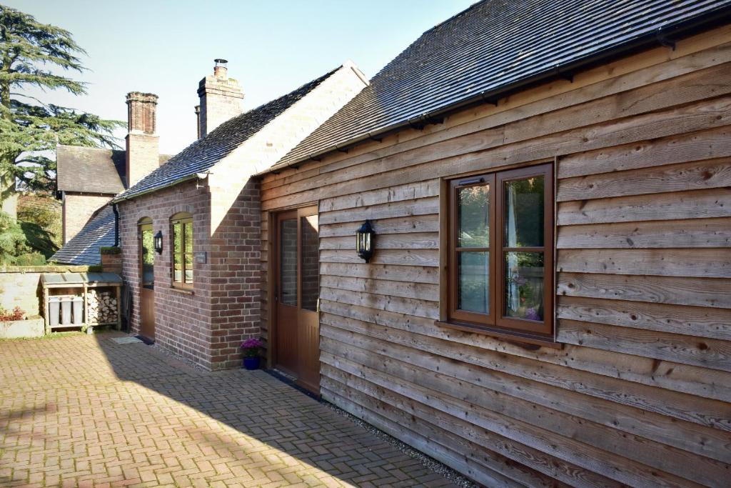 Finest Retreats - Shropshire Cottage, 2 bedrooms, sleeps 3 في Marchamley: منزل خشبي على جانبه نافذة