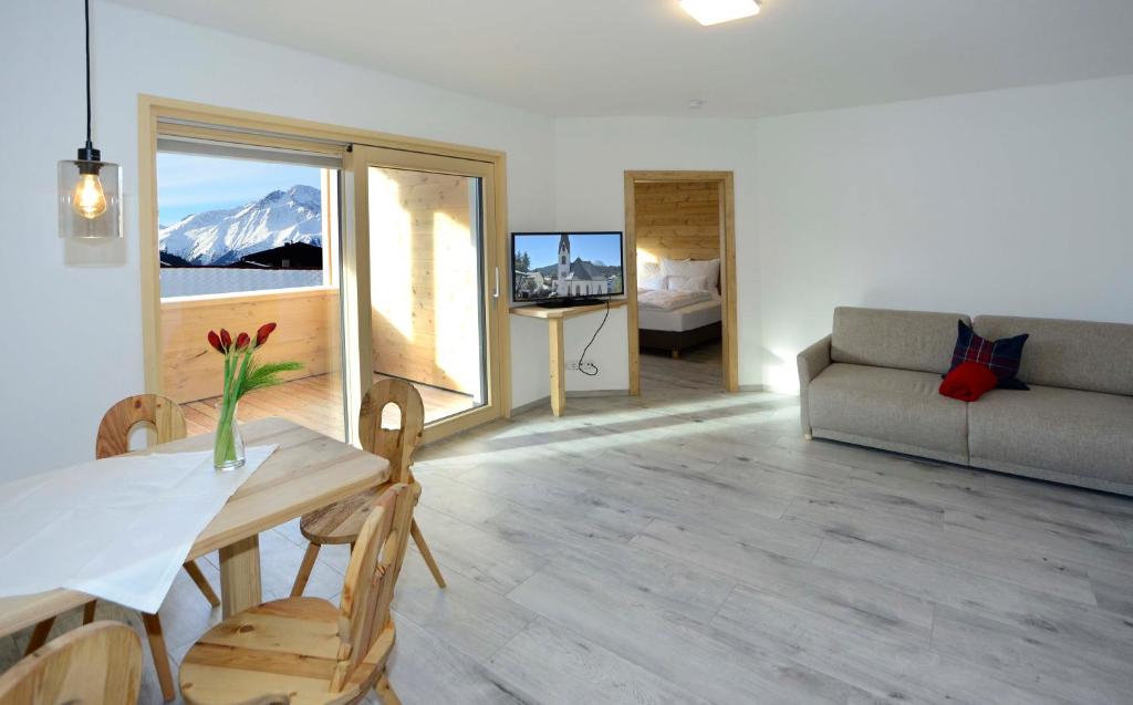een woonkamer met een tafel en een bank bij Birklstüberl Restaurant und Appartement in Seefeld in Tirol