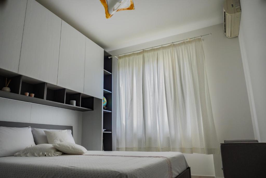 Schlafzimmer mit einem Bett und einem Fenster in der Unterkunft Spicchio di Luna in Pontinia