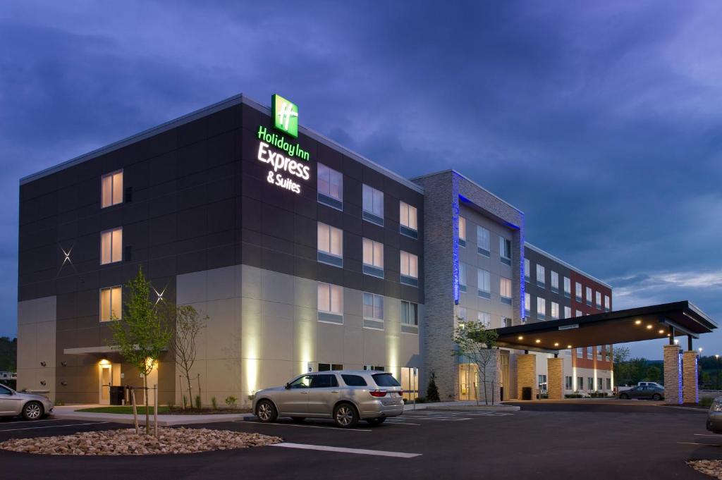 a building with a car parked in a parking lot at Holiday Inn Express & Suites by IHG Altoona, an IHG Hotel in Altoona