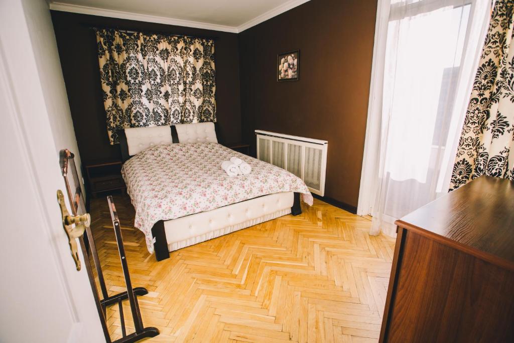 Schlafzimmer mit einem Bett und Holzboden in der Unterkunft Amazing view of Maydan! in Kiew