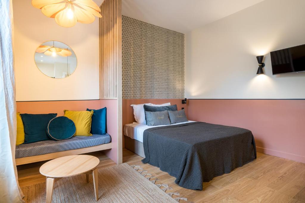 een slaapkamer met een bed, een stoel en een tafel bij HONORÊ - SUITE ARBRE SEC in Lyon