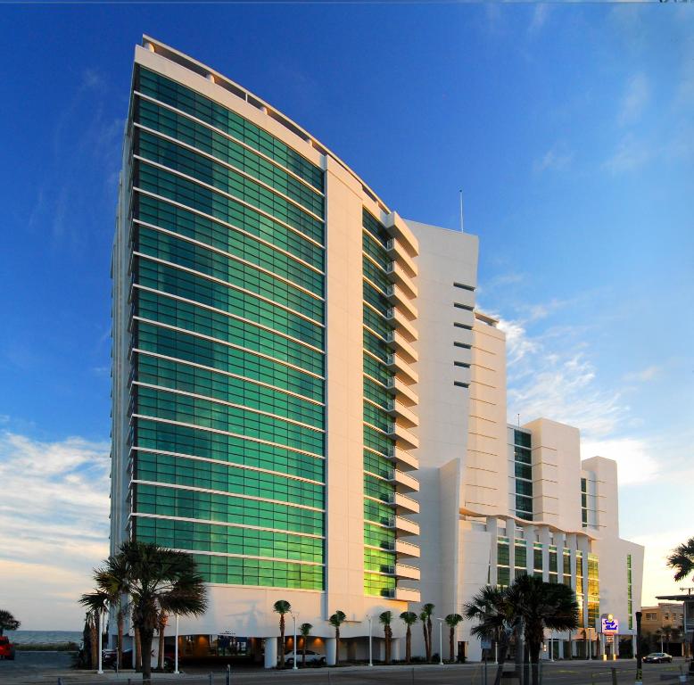 a tall building with palm trees in front of it at Sandy Beach Resort in Myrtle Beach