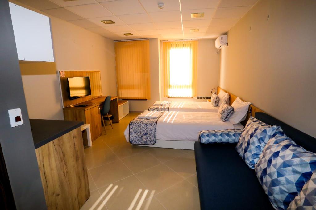 une chambre d'hôtel avec un lit et une télévision dans l'établissement Студия и Стаи за гости -жк Пентагон, à Kardjali