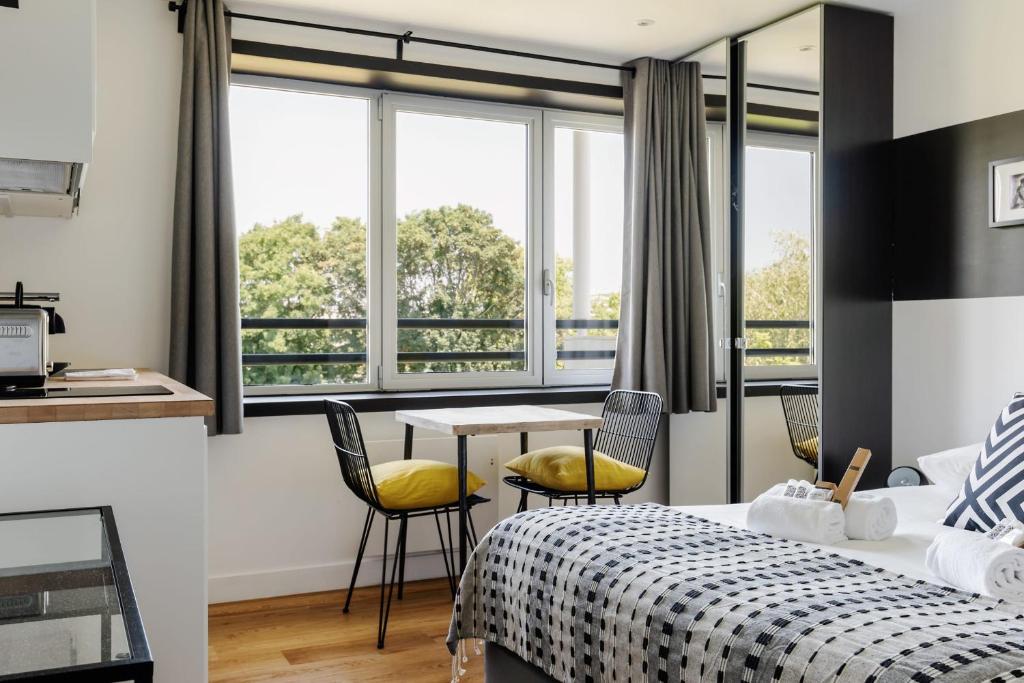 a bedroom with a bed and a table with chairs at GuestReady - Charming studio in Issy-les-Moulineaux in Issy-les-Moulineaux