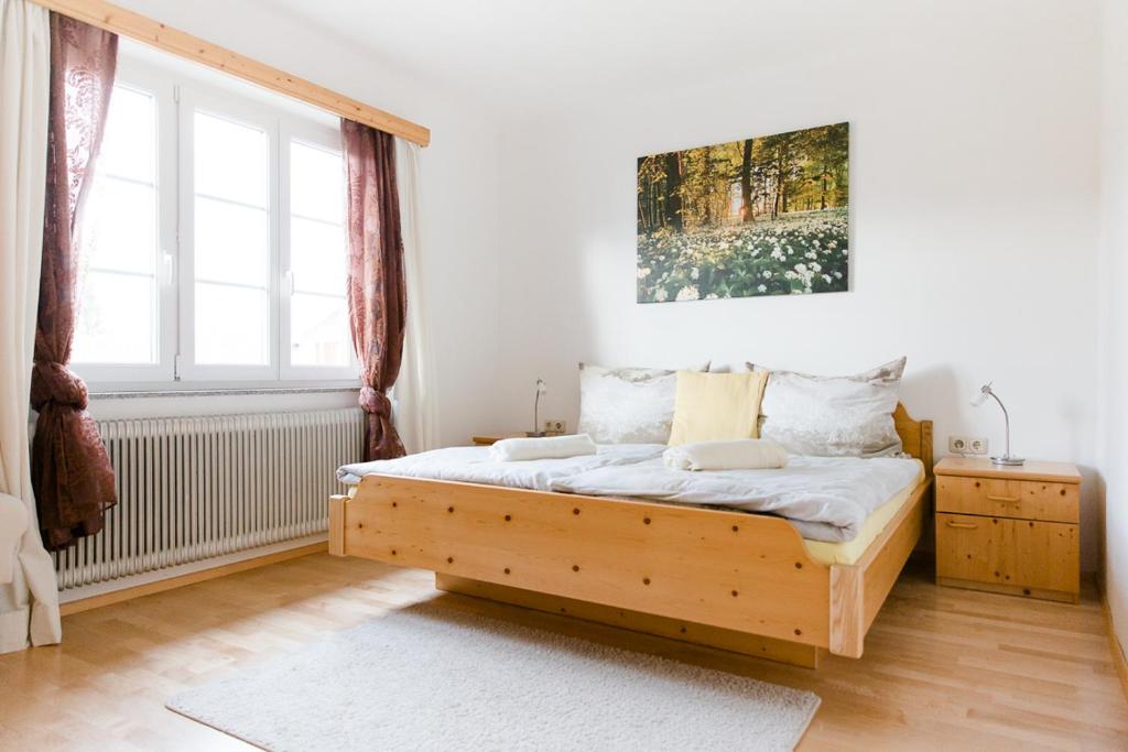 um quarto com uma cama de madeira e uma janela em Wohnung am See em Steinbach am Attersee