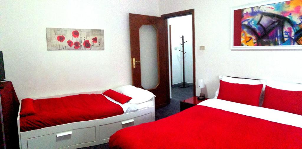 2 Betten in einem rot-weißen Zimmer in der Unterkunft APT. Re Nasone in Caserta
