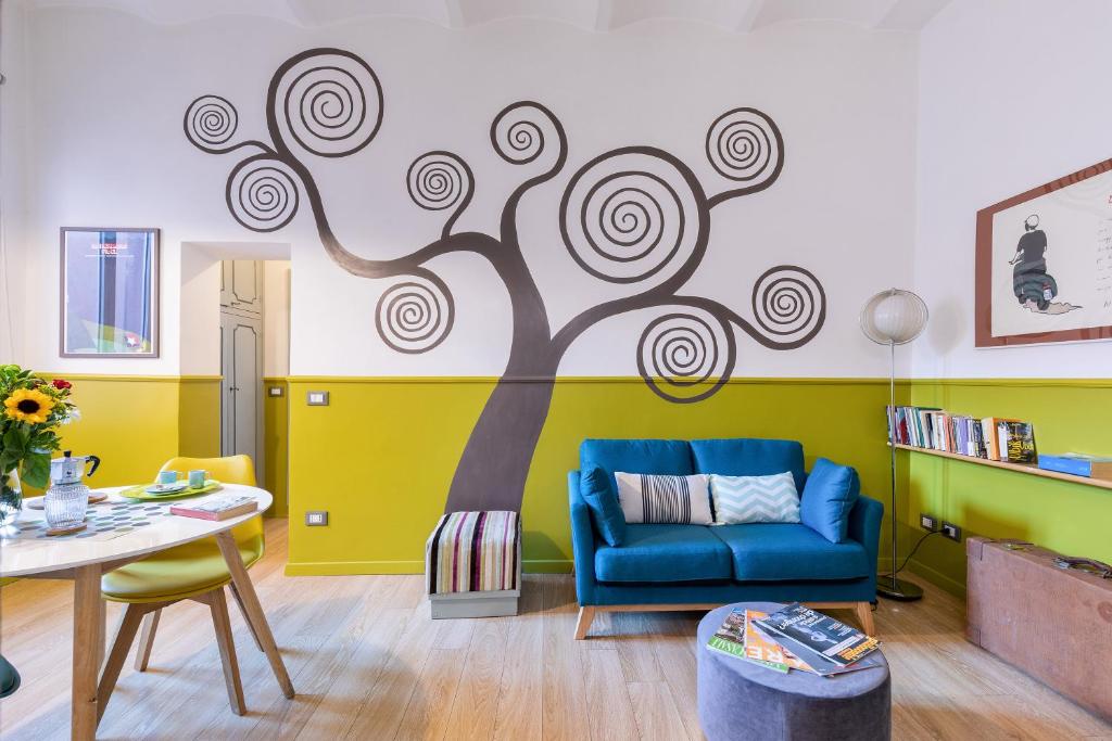 a living room with a tree mural on the wall at Rome As You Feel - Orti Trastevere Apartment in Rome