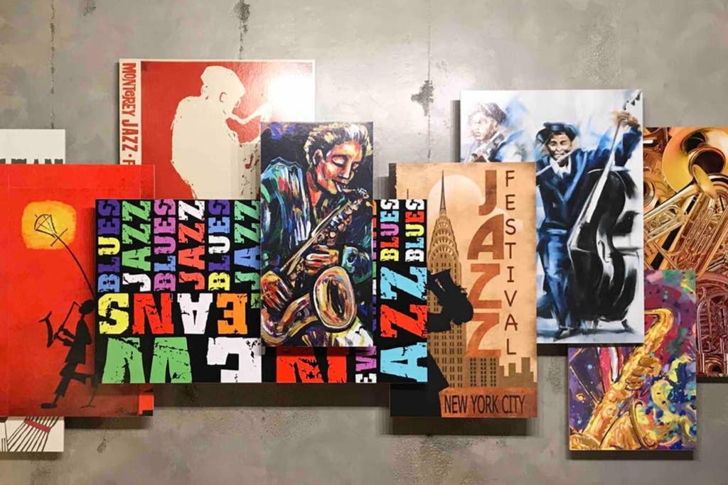 un collage d'affiches sur un mur dans l'établissement JAZZAPPART appartement classé 3 étoiles, à Gentilly