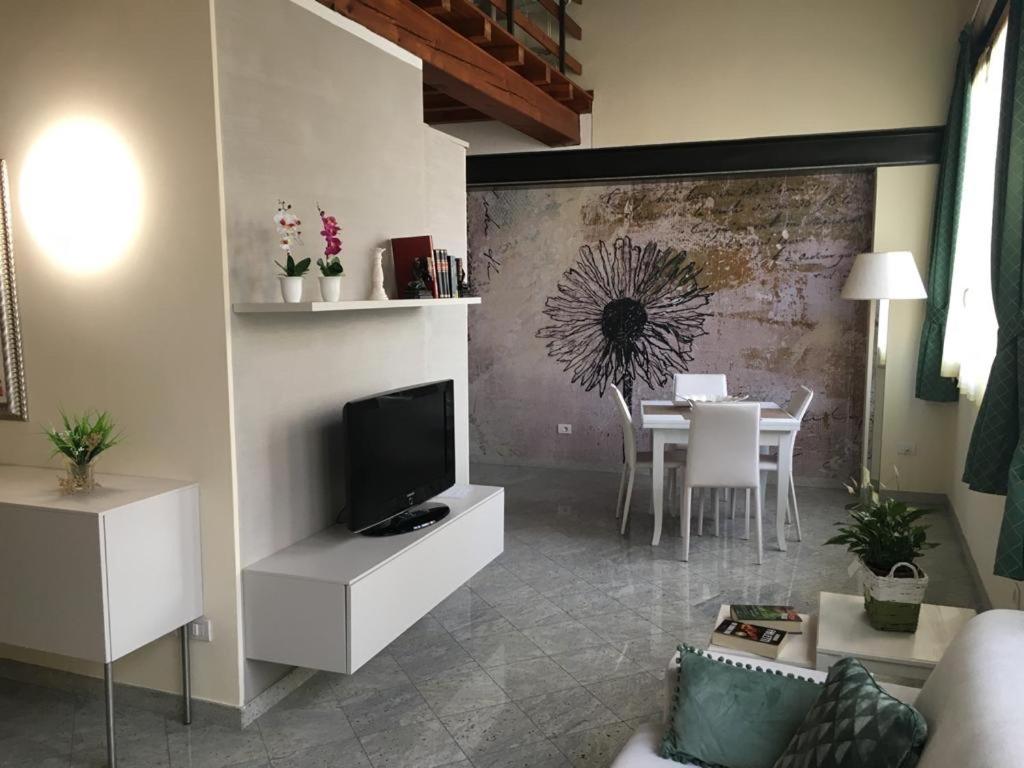 sala de estar con TV y comedor en Il Vicoletto holiday house en Volta Mantovana