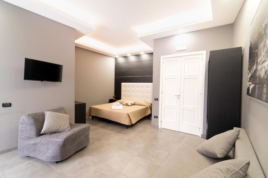 a room with a bedroom with a bed and a chair at Royal Art H Spaccanapoli, by ClaPa Group in Naples