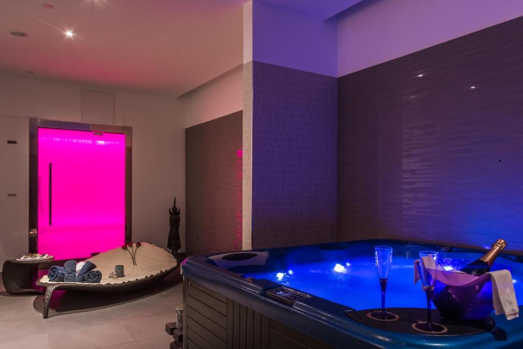 a large bathroom with a tub with a pink light at Royal Palm Resort & Spa - Adults Only in Playa Jandia