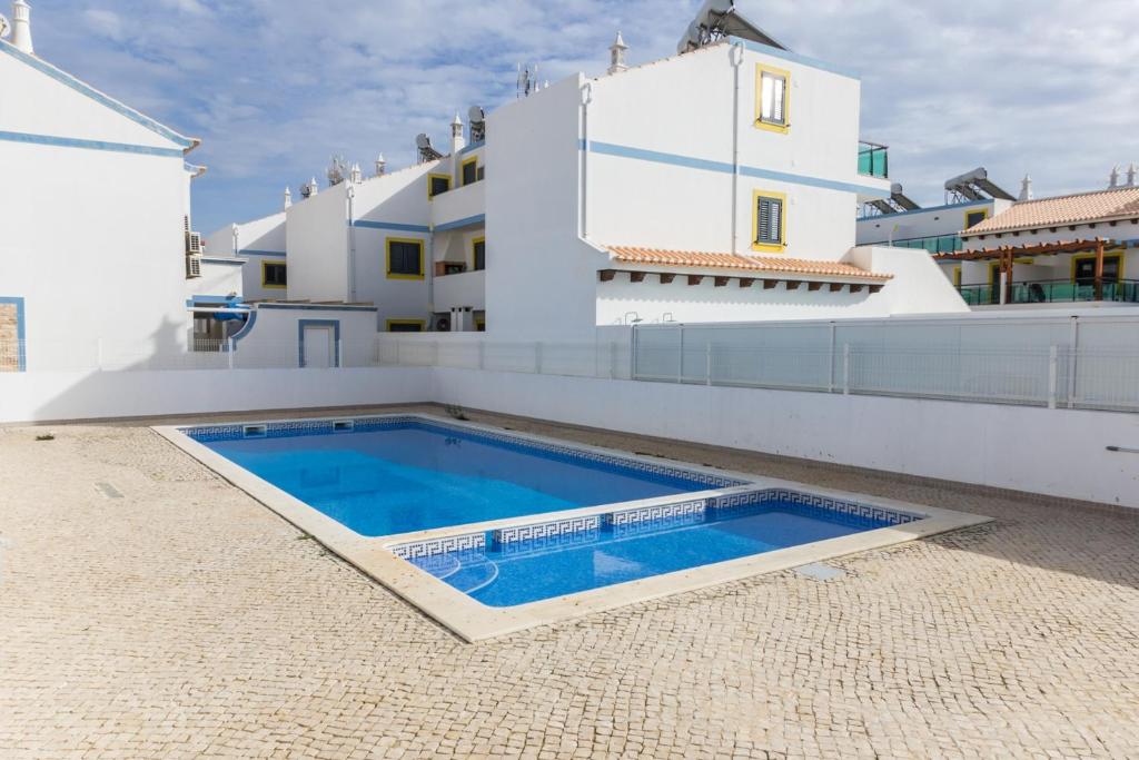 a swimming pool on the roof of a house at Mira Praia Villa by ALGARVEMANTA in Manta Rota
