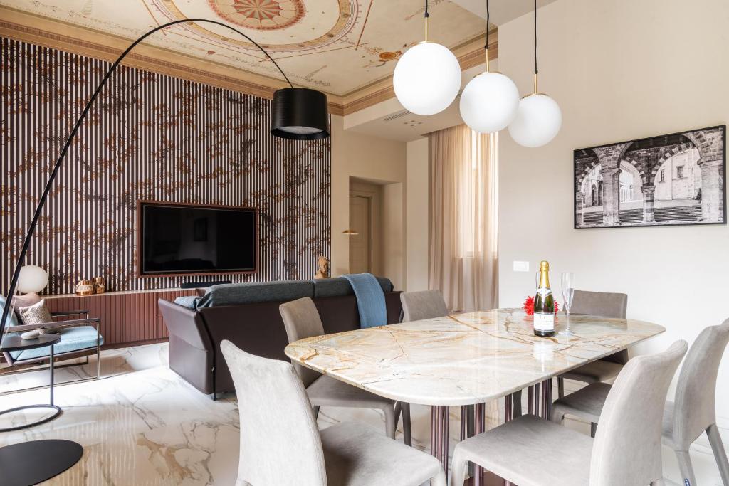 een woonkamer met een tafel en stoelen bij Palazzo Visconti - by MyHomeInComo in Como
