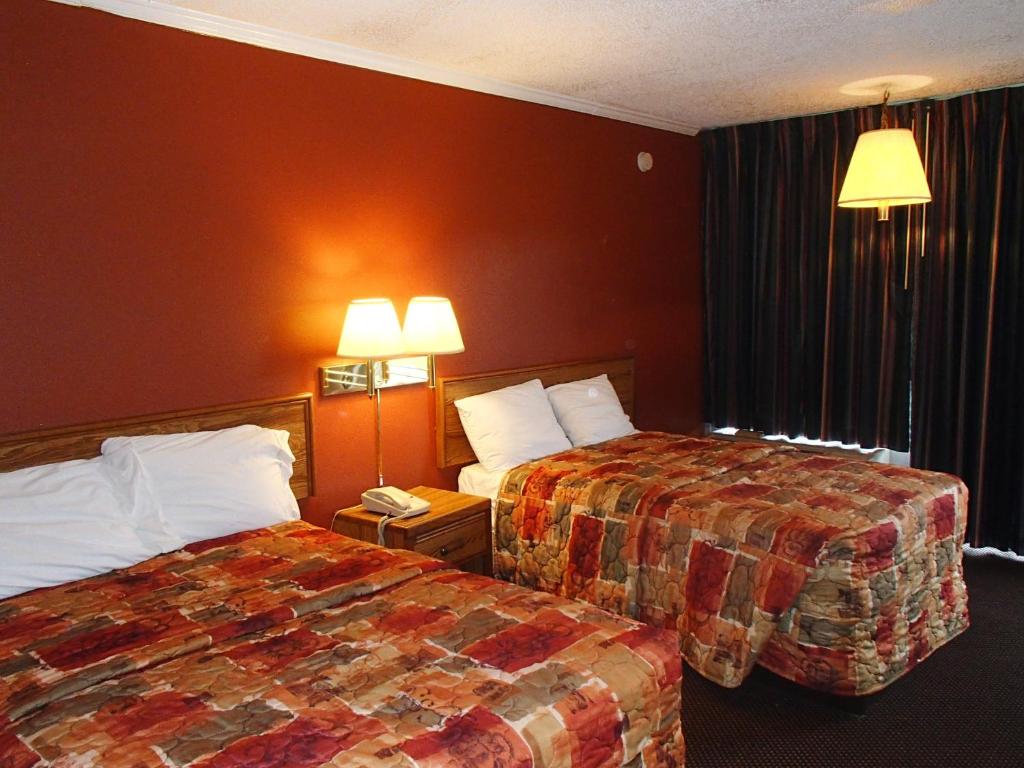 um quarto de hotel com duas camas ao lado uma da outra em Sunrise Inn Lake Charles em Lake Charles