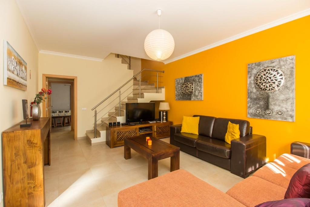 a living room with a couch and a tv at Villa Amoreira by ALGARVEMANTA in Manta Rota