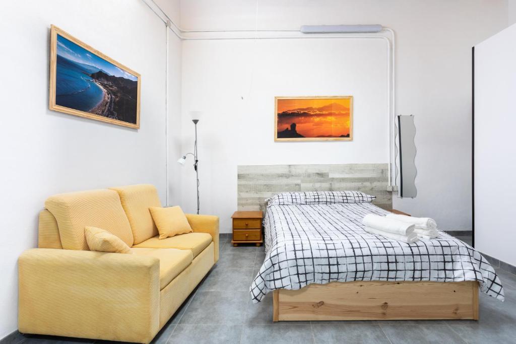 a bedroom with a bed and a couch at Estudio La Hornera in La Laguna
