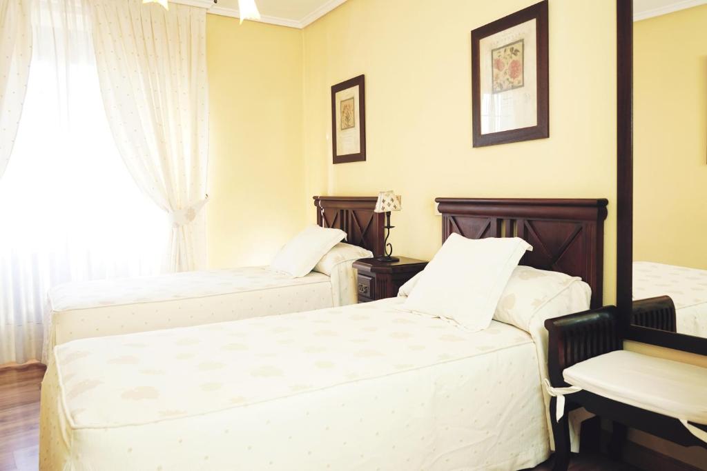a bedroom with two beds and a window at DC Mesones 21 in Lerma