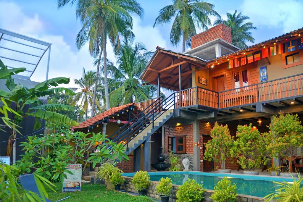 a house with a staircase next to a swimming pool at Negombo The Nature Villa and Cabanas in Negombo