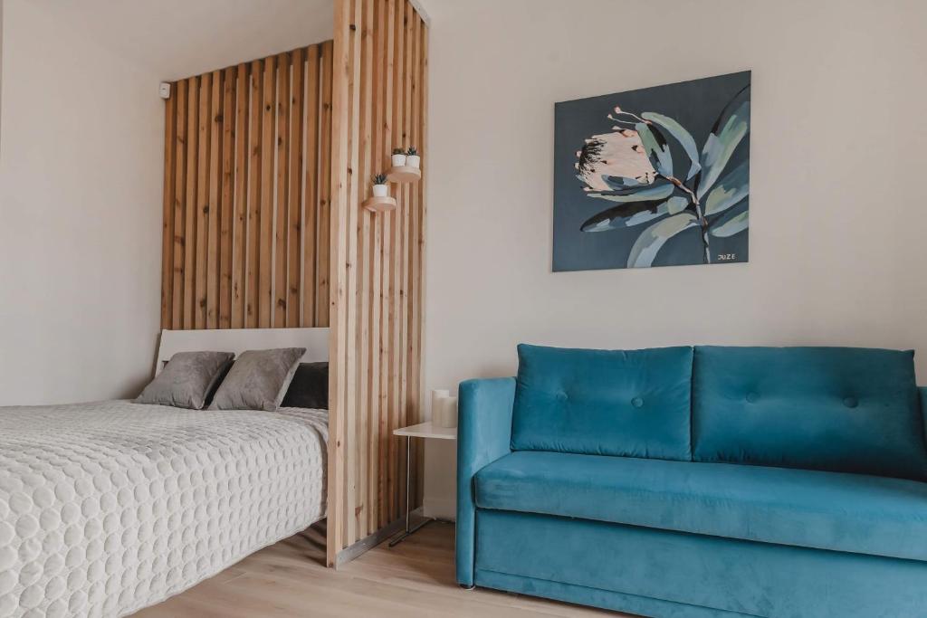 um quarto com uma cama e uma cadeira azul em Apartment Mona em Palanga