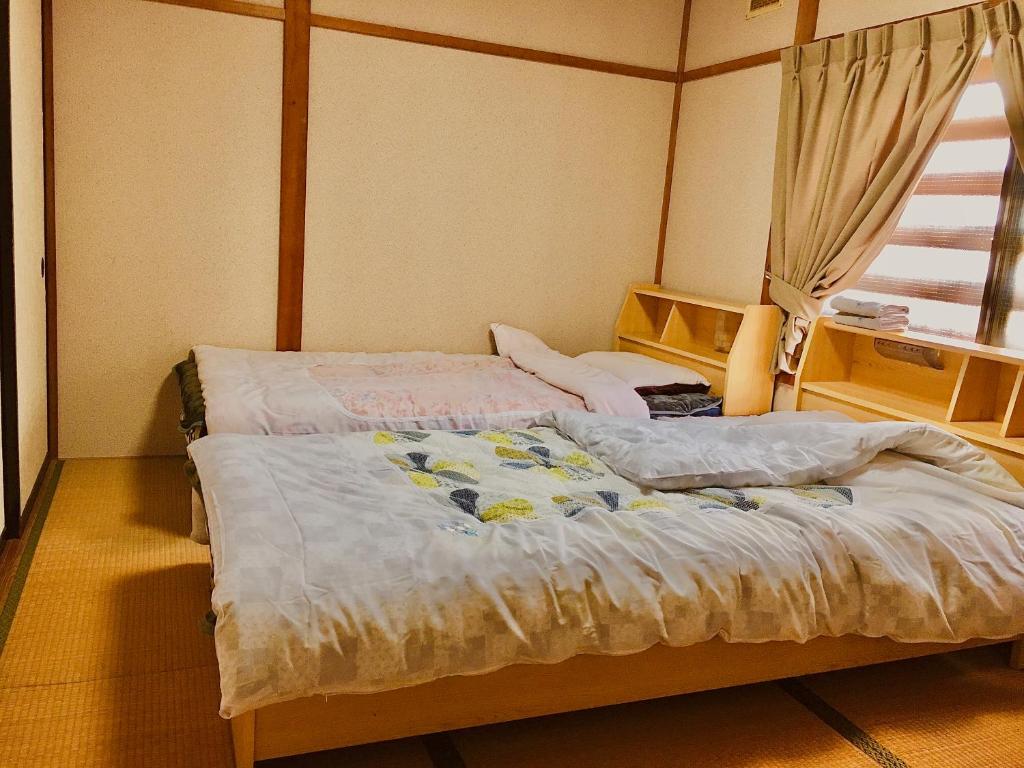 a bedroom with two beds and a window at オイソ in Iiyama