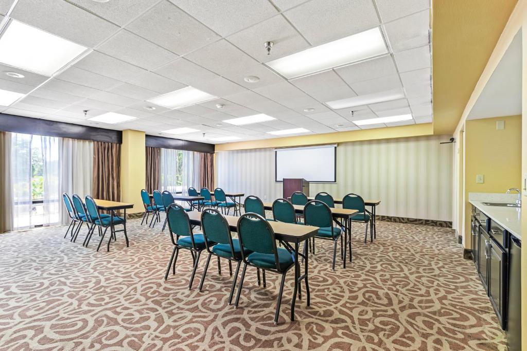 a conference room with tables and chairs and a screen at Holiday Inn - St. Petersburg West by IHG in St Petersburg