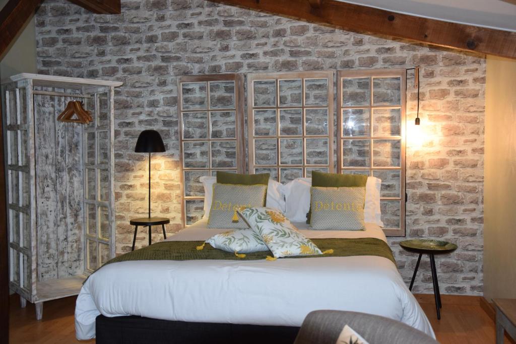 a bedroom with a large white bed with a brick wall at Les Portes Du Hable in Cayeux-sur-Mer