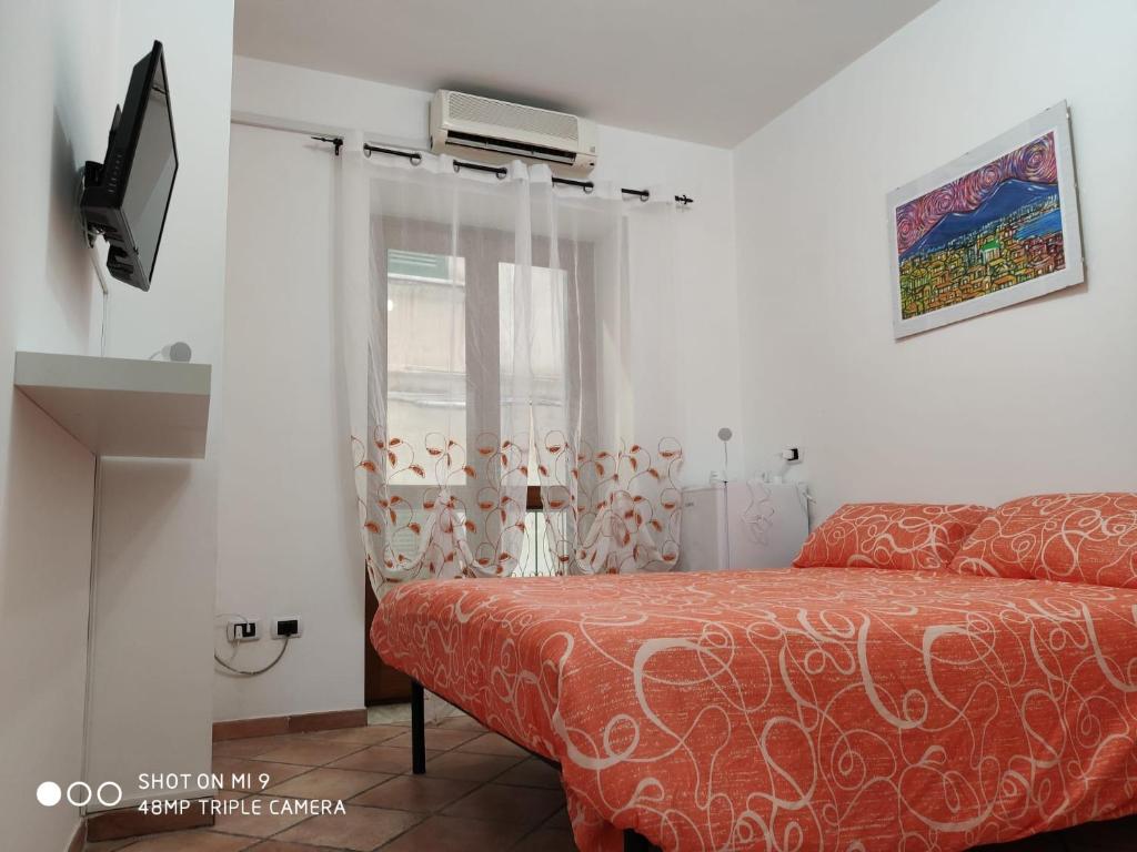 um quarto com uma cama e uma janela em La dimora di bronzo em Nápoles