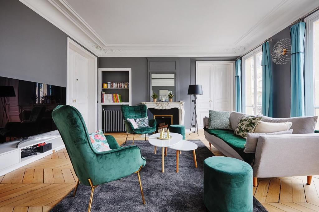 a living room with green chairs and a couch at Veeve - Emerald Exuberance in Paris