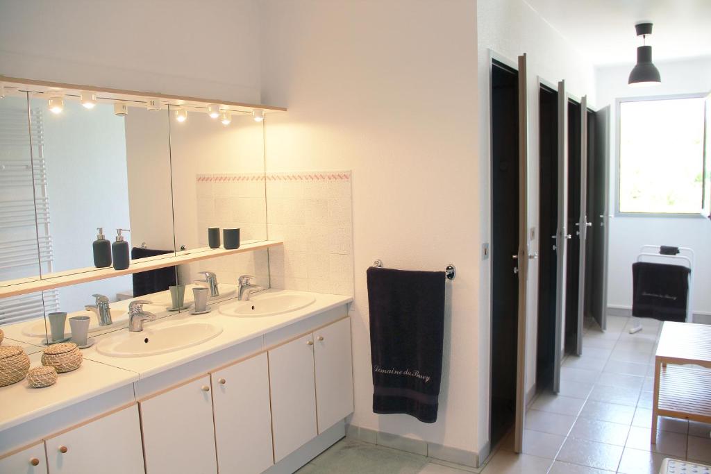 a bathroom with two sinks and a large mirror at Domaine du Barvy in Odenas
