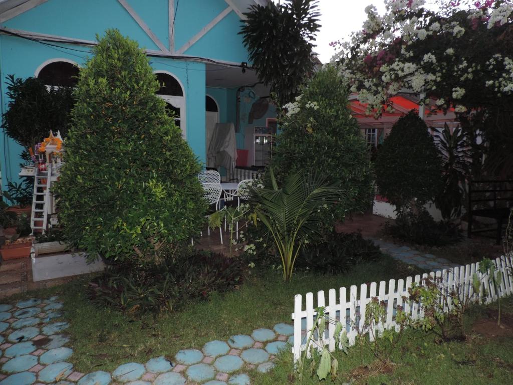 a white fence in front of a house with trees at Blue Paradise Residence in Rawai Beach