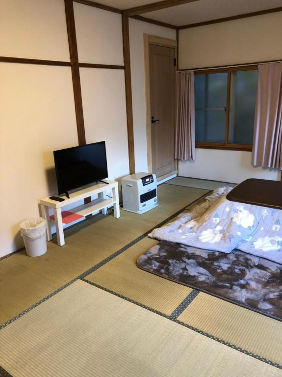 a living room with a flat screen tv and a living room at Oyado Zen in Kusatsu