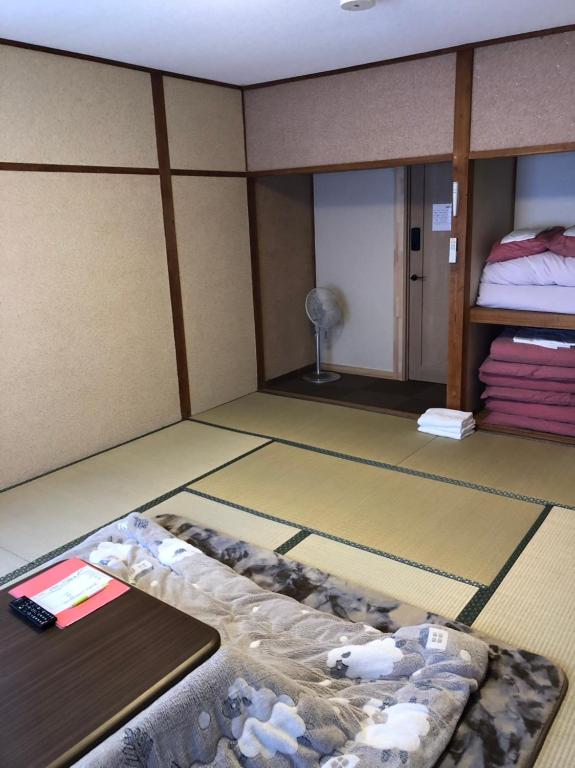 a room with a room with a bed and a room with at Oyado Zen in Kusatsu