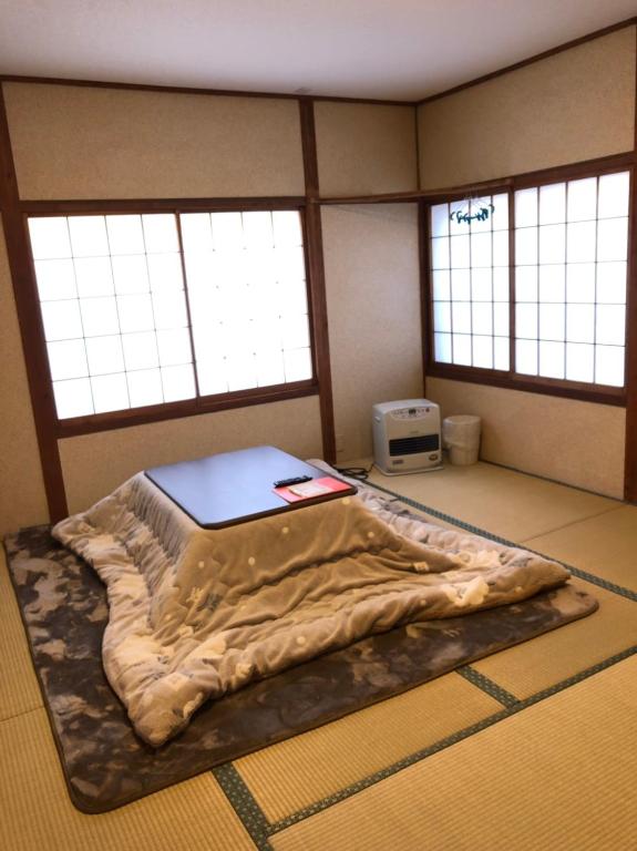 a large bed in a room with two windows at Oyado Zen in Kusatsu