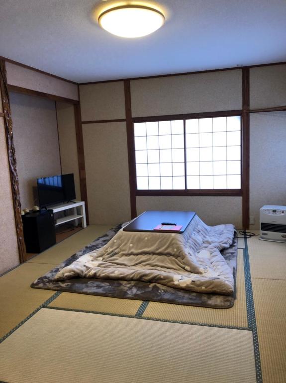 a room with a bed with a laptop on it at Oyado Zen in Kusatsu