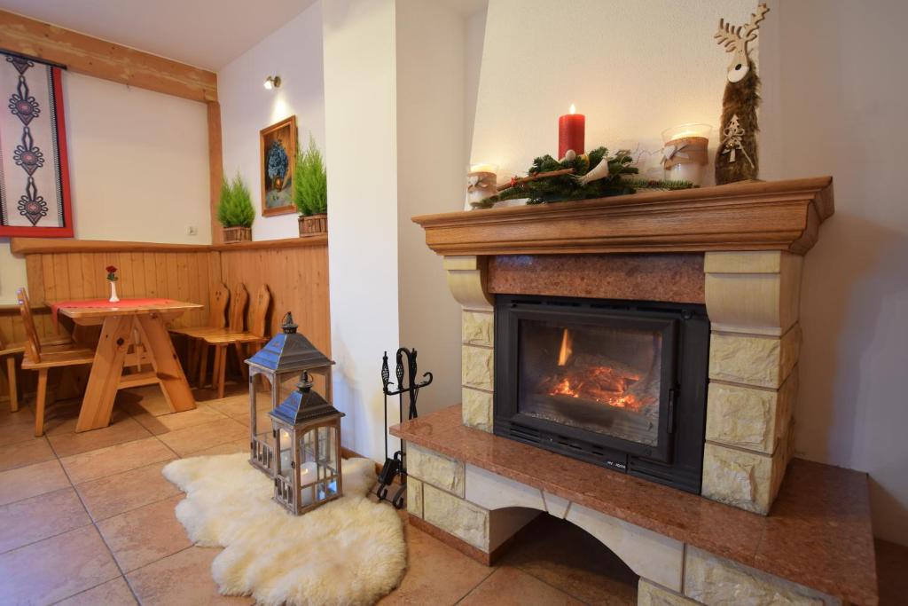 a living room with a fireplace and a table at Willa Świdrówka 2 in Poronin