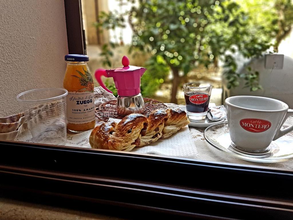 un tavolo con pasticcini e una tazza di caffè su una finestra di A due passi dal centro e dal mare a Marsala
