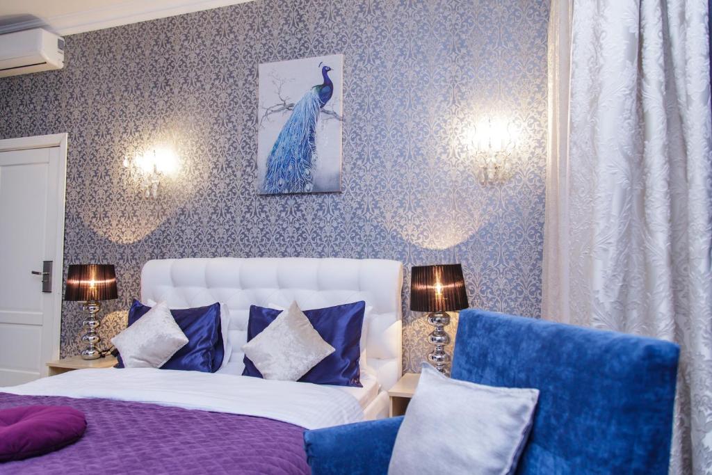 a bedroom with a white bed and a blue dress on the wall at Mira Hotel in Moscow
